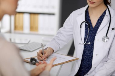 Doktor ve hasta klinikte otururken sağlık muayenesini tartışıyorlar. Hastanede mükemmel bir tıbbi hizmet. Tıp konsepti