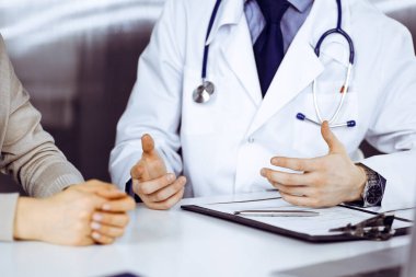 Bilinmeyen erkek doktor ve hasta kadın klinikte otururken bir şey tartışıyorlar. Hastanedeki en iyi sağlık hizmeti, ilaç, salgın durdurma.