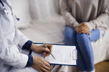 Bilinmeyen kadın doktor ve hasta içeride otururken sağlık muayenesini tartışıyorlar. Coronavirus salgını ve kendini izolasyon karantinası süresince evde kal