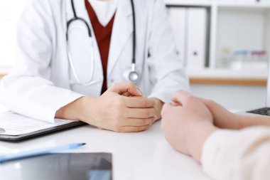 Bilinmeyen kadın doktor ve hasta klinikteki masada otururken bir şey tartışıyorlar, yakın plan. Tıp konsepti