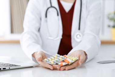 Bilinmeyen kadın doktor farklı tablet kabarcıkları sunuyor, yakın plan. Tıp konsepti