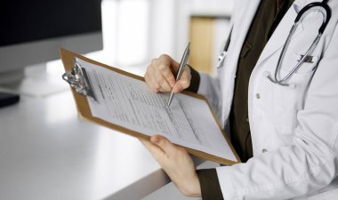 Klinikte pano kullanan neşeli gülümseyen kadın doktor. İş yerindeki dost canlısı doktor kadın portresi. Hastanede mükemmel bir tıbbi hizmet. Tıp konsepti