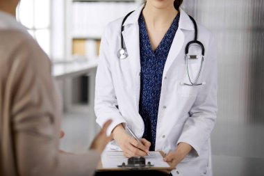 Doktor ve hasta klinikte otururken sağlık muayenesini tartışıyorlar. Hastanede mükemmel bir tıbbi hizmet. Tıp konsepti