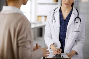 Doktor ve hasta klinikte otururken sağlık muayenesini tartışıyorlar. Hastanede mükemmel bir tıbbi hizmet. Tıp konsepti