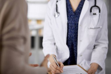 Doktor ve hasta klinikte otururken sağlık muayenesini tartışıyorlar. Hastanede mükemmel bir tıbbi hizmet. Tıp konsepti