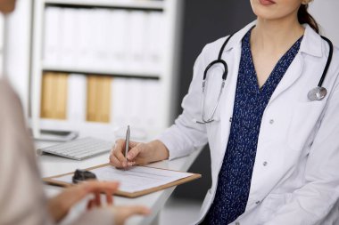 Doktor ve hasta klinikte otururken sağlık muayenesini tartışıyorlar. Hastanede mükemmel bir tıbbi hizmet. Tıp konsepti