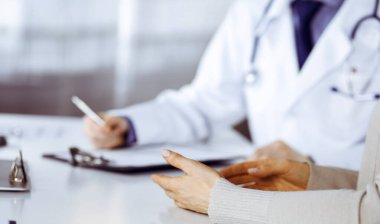 Bilinmeyen erkek doktor ve hasta kadın klinikte oturup dosya kullanırken bir şey tartışıyorlar. Hastanedeki en iyi sağlık hizmeti, ilaç, salgın durdurma.