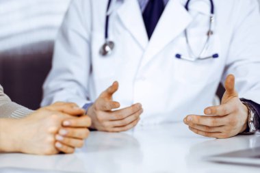 Bilinmeyen erkek doktor ve hasta kadın klinikte otururken bir şey tartışıyorlar. Hastanedeki en iyi sağlık hizmeti, ilaç, salgın durdurma.