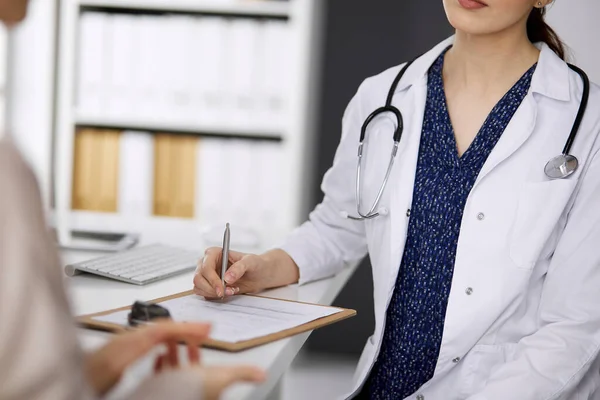 Doktor ve hasta klinikte otururken sağlık muayenesini tartışıyorlar. Hastanede mükemmel bir tıbbi hizmet. Tıp konsepti