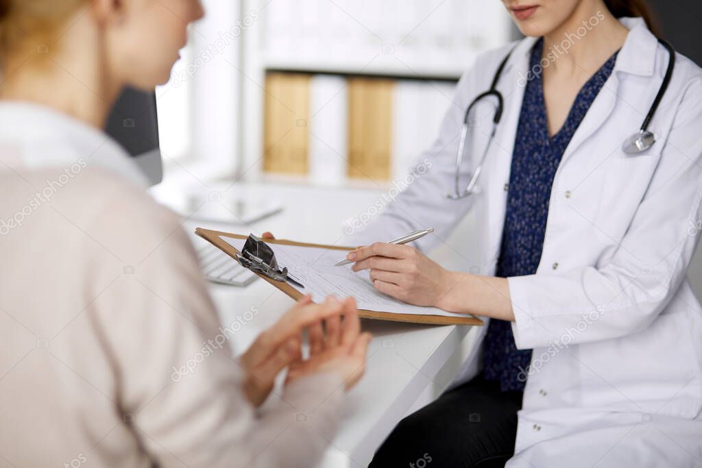 Doctor and patient discussing current health examination while sitting in clinic. Perfect medical service in hospital. Medicine concept