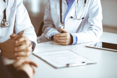 Meçhul erkek doktor modern klinikte otururken hasta kadını dinliyor. Mükemmel tıbbi servis, Coronavirus salgını sırasında ilaç konsepti. Covid 2019