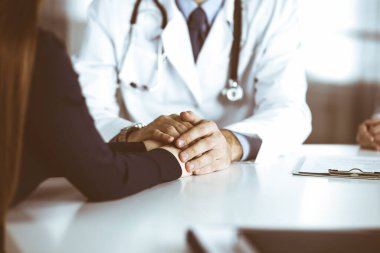 Bilinmeyen erkek-doktor, kadın hastasına güvence veriyor, yakın plan. İki doktor kadınlara danışmanlık yapıyor ve tavsiyelerde bulunuyor. Mükemmel tıbbi hizmet, Coronavirus salgını sırasında tıpta empati. Kapalı