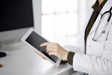 Klinikte tablet bilgisayar kullanan kimliği belirsiz kadın doktor. Hastanede mükemmel bir tıbbi hizmet. Tıp konsepti