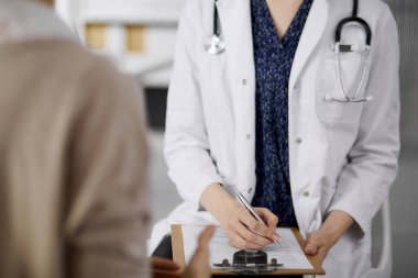 Doktor ve hasta klinikte otururken sağlık muayenesini tartışıyorlar. Hastanede mükemmel bir tıbbi hizmet. Tıp konsepti