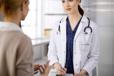 Doktor ve hasta klinikte otururken sağlık muayenesini tartışıyorlar. Hastanede mükemmel bir tıbbi hizmet. Tıp konsepti