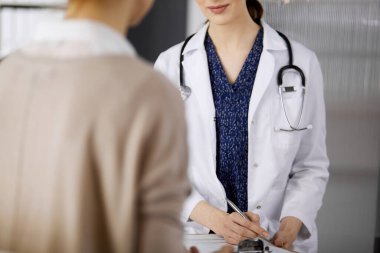 Doktor ve hasta klinikte otururken sağlık muayenesini tartışıyorlar. Hastanede mükemmel bir tıbbi hizmet. Tıp konsepti