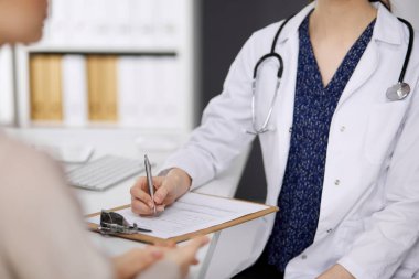 Doktor ve hasta klinikte otururken sağlık muayenesini tartışıyorlar. Hastanede mükemmel bir tıbbi hizmet. Tıp konsepti