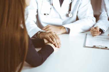 Bilinmeyen erkek-doktor, kadın hastasına güvence veriyor, yakın plan. İki doktor kadınlara danışmanlık yapıyor ve tavsiyelerde bulunuyor. Mükemmel tıbbi hizmet, Coronavirus salgını sırasında tıpta empati. Kapalı