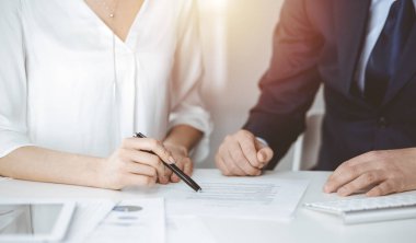Bilinmeyen işadamı ve kadın güneşli ofiste sözleşmeyi tartışıyorlar, yakın plan. İş adamları veya avukatlar toplantıda birlikte çalışıyorlar.