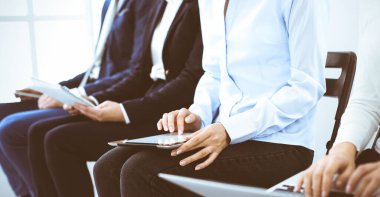 Ofiste çalışan bir grup iş adamı, yakın plan. Bilgisayarda daktilo eden iş kadını. Konferans, eğitim veya toplantı kavramları