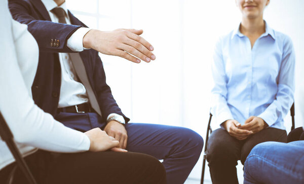 Группа людей, сидящих в кругу во время терапии в офисе. Встреча бизнес-команды, участвующей в тренинге