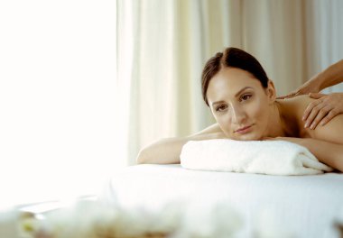 Güzel esmer kadın spa salonunda sırt masajı yaptırıyor. Güzellik konsepti