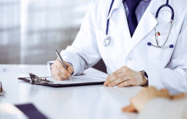Bilinmeyen erkek doktor ve hasta kadın klinikte oturup dosya kullanırken bir şey tartışıyorlar. Hastanedeki en iyi sağlık hizmeti, ilaç, salgın durdurma.
