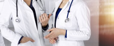 İki kadın hekim klinikteki masada dururken tıbbi terapiyi tartışıyorlar. Doktorlar işte bilgisayar kullanırlar. Tıpta takım çalışması