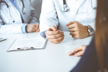 Meçhul erkek doktor modern klinikte otururken hasta kadını dinliyor. Mükemmel tıbbi servis, Coronavirus salgını sırasında ilaç konsepti. Covid 2019