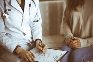 Bilinmeyen kadın doktor ve hasta içeride otururken sağlık muayenesini tartışıyorlar. Coronavirus salgını ve kendini izolasyon karantinası süresince evde kal