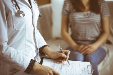 Bilinmeyen kadın doktor ve hasta sıcak oturma odasında otururken sağlık muayenesini tartışıyorlar. Coronavirus salgını ve kendini izolasyon karantinası süresince evde kal