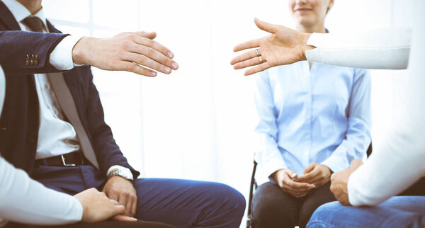 Группа людей, сидящих в кругу во время терапии в офисе. Встреча бизнес-команды, участвующей в тренинге