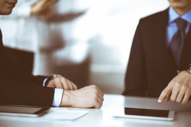 İş adamları modern bir ofiste birlikte çalışırken bir tablet bilgisayar kullanırlar. Bilinmeyen iş adamı ya da erkek girişimci masada meslektaşı ve sekreteriyle oturuyor.