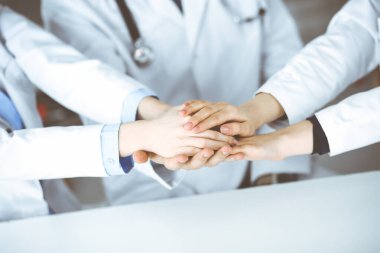 Bir grup modern doktor el ele verip hastalara yardım etmeye hazır. Coronavirus salgını sırasında tıpta takım çalışması. Covid 2019