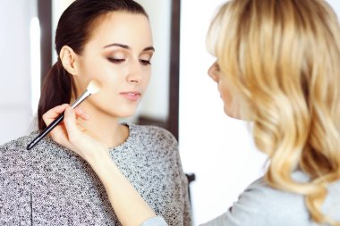 Profesyonel makyöz güzel genç bir kadınla çalışıyor. Gelin, moda ya da çıplak stil