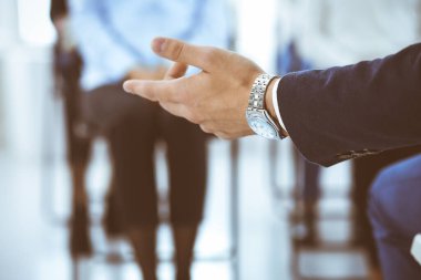 İş adamı ofisteki bir grup insana sunum yapıyor. Sözcü meslektaşlarına seminer ya da iş eğitimi veriyor. İş hayatında takım çalışması ve koçluk kavramları