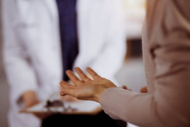 Doktor ve hasta güneşli klinikte otururken sağlık muayenesini tartışıyorlar. Hastanede mükemmel bir tıbbi hizmet.