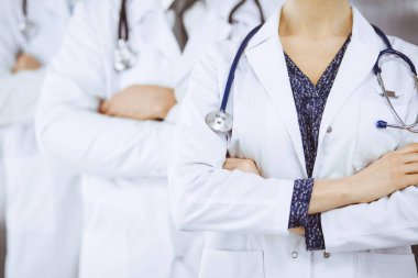 Doktorlar klinikte kollarını kavuşturmuş bir takım gibi duruyorlar. Tıbbi yardım, sigorta ve tıp konsepti