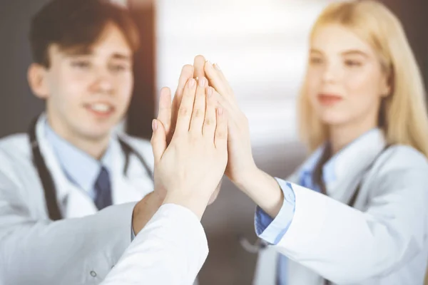 Un gruppo di medici moderni si uniscono e si danno cinque a vicenda come segno di un forte lavoro di squadra e pronti ad aiutare i pazienti. Contro il coronavirus e il concetto di medicina — Foto Stock