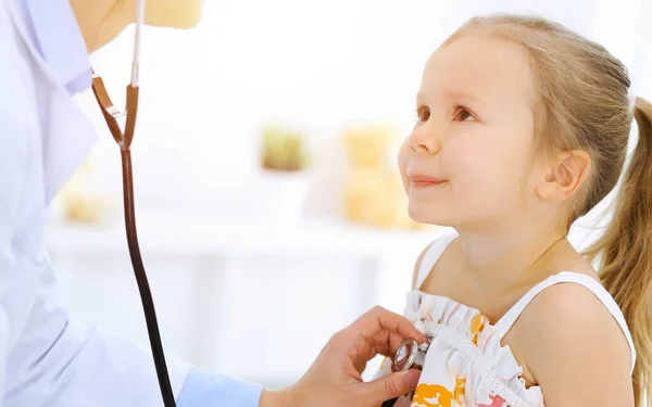 Γιατρός εξετάζει ένα κοριτσάκι με στηθοσκόπιο. Χαρούμενος χαμογελαστός ασθενής στη συνηθισμένη ιατρική εξέταση. Έννοιες ιατρικής και υγειονομικής περίθαλψης — Φωτογραφία Αρχείου