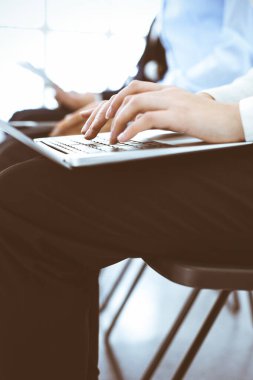 Ofiste çalışan bir grup iş adamı, yakın plan. Bilgisayarda daktilo eden iş kadını. Konferans, eğitim veya toplantı kavramları