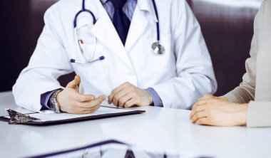 Bilinmeyen erkek doktor ve hasta kadın klinikte otururken bir şey tartışıyorlar. Hastanedeki en iyi sağlık hizmeti, ilaç, salgın durdurma.