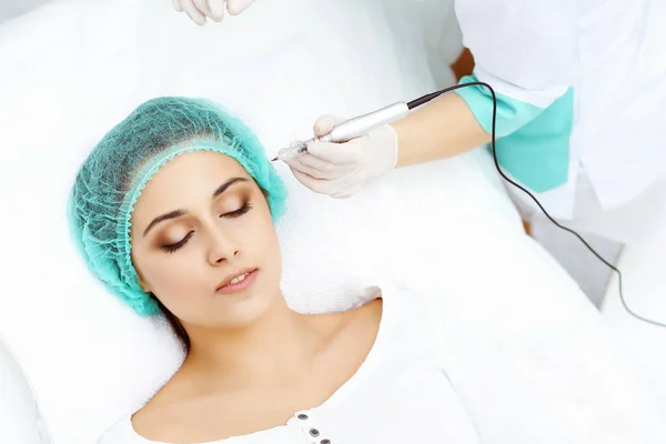 Esteticista profesional haciendo tatuaje de cejas en la cara de la mujer. Maquillaje de frente permanente en salón de belleza, primer plano. Tratamiento de la cosmetología — Foto de Stock