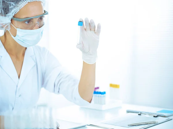 Cientista profissional em óculos de proteção pesquisando tubo com reagentes em laboratório tonificado em azul. Conceitos de medicina e pesquisa científica — Fotografia de Stock