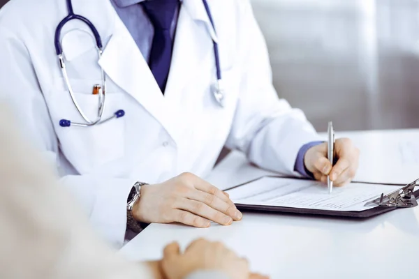 Bilinmeyen erkek doktor ve hasta kadın klinikte oturup dosya kullanırken bir şey tartışıyorlar. Hastanedeki en iyi sağlık hizmeti, ilaç, salgın durdurma.