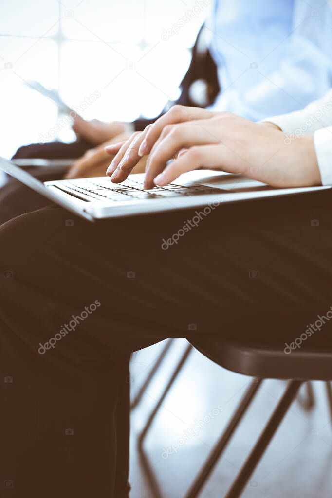 Group of business people working in office, close-up. Businesswoman typing on laptop. Conference, training or meeting concepts