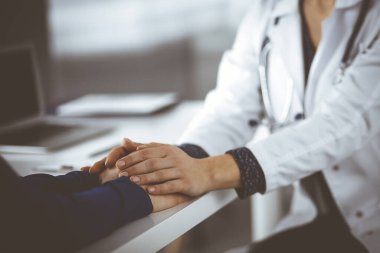 Bilinmeyen kadın doktor, kadın hastasına güvence veriyor, yakın plan. Doktor bir kadına danışmanlık yapıyor ve tavsiyelerde bulunuyor. Tıbbi ahlak ve güven kavramları. Tıpta empati