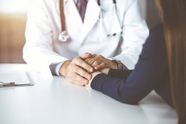 Bilinmeyen erkek-doktor, kadın hastasına güvence veriyor, yakın plan. Mükemmel tıbbi hizmet, Coronavirus salgını sırasında tıpta empati.