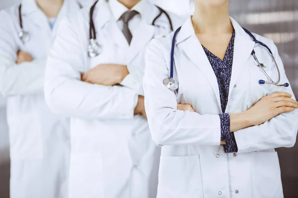 Medici in piedi come una squadra con le braccia incrociate in clinica. Concetto di assistenza medica, assicurazione e medicina — Foto Stock