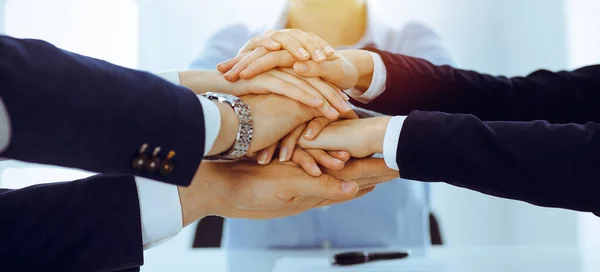 Geschäftsteam zeigt im sonnigen Büro Geschlossenheit mit den Händen. Gruppe von Menschen, die sich die Hände reichen und das Konzept der Freundschaft und Teamarbeit repräsentieren — Stockfoto